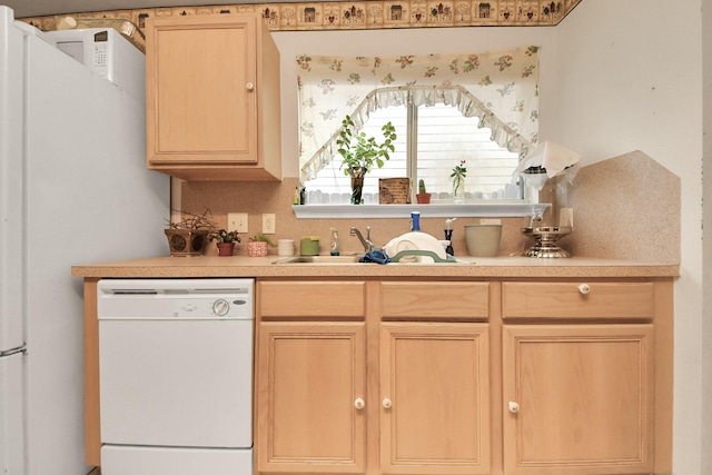 kitchen featuring a sink, light brown cabinets, white dishwasher, and light countertops