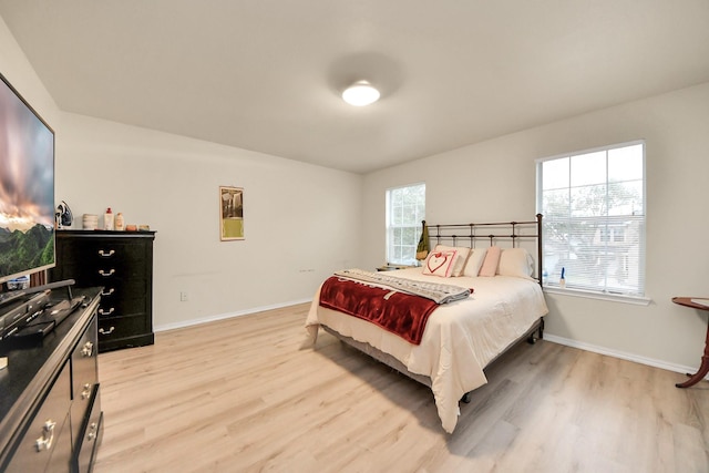 bedroom featuring light wood-style floors and baseboards