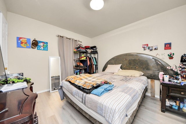 bedroom featuring light wood finished floors and baseboards