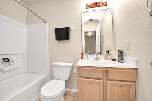 bathroom with vanity, toilet, tub / shower combination, and baseboards