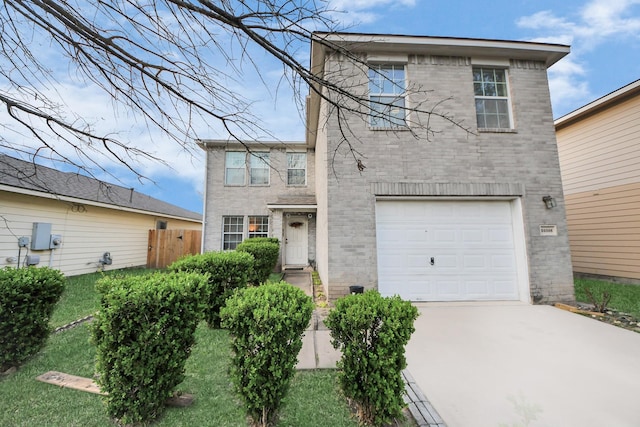 traditional-style house with brick siding, an attached garage, concrete driveway, and fence