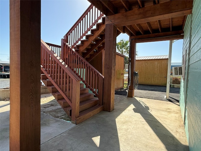 view of patio with an outbuilding and stairway