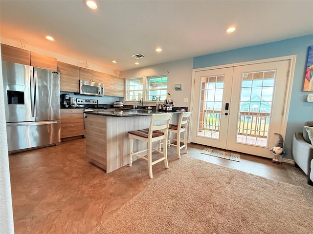 kitchen with recessed lighting, stainless steel appliances, dark countertops, and french doors