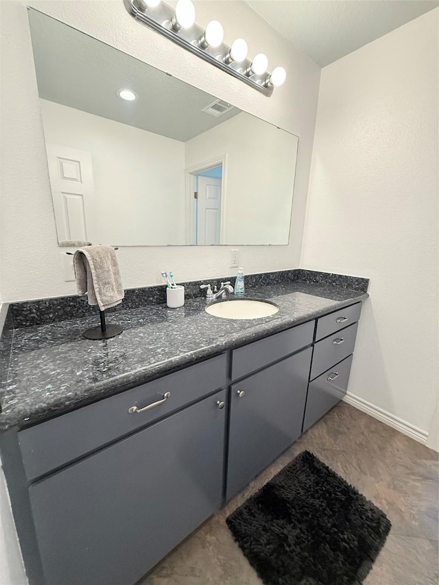 bathroom featuring vanity, visible vents, and baseboards