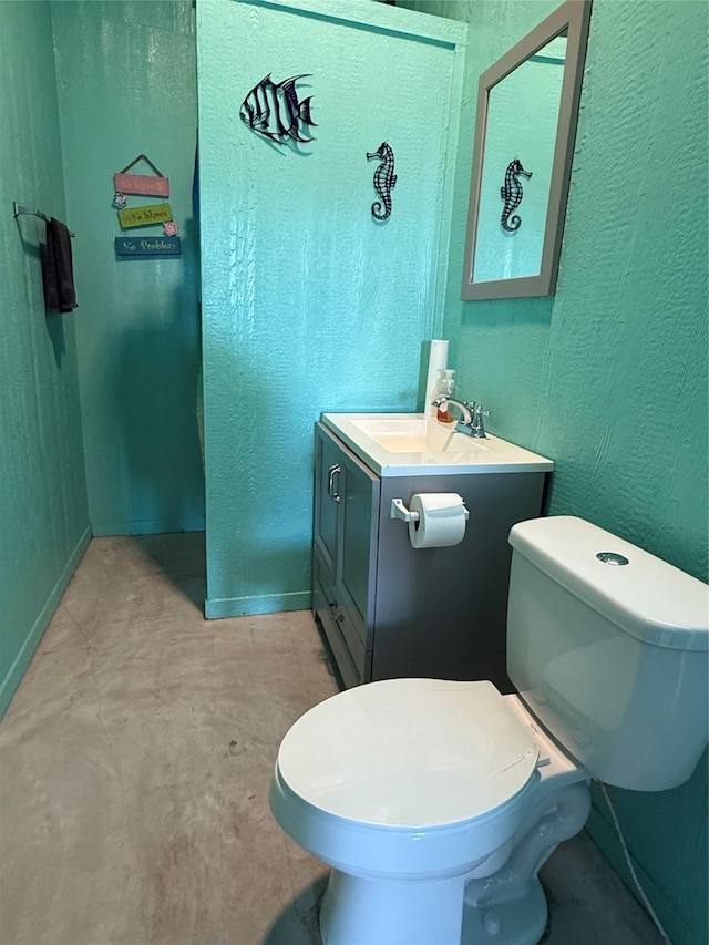 half bathroom with toilet, vanity, and a textured wall