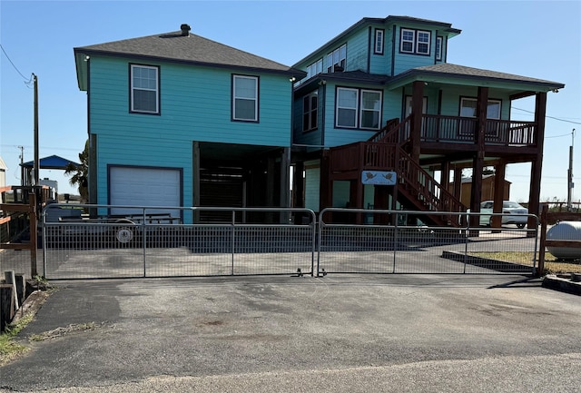 view of front of house featuring a garage, a shingled roof, concrete driveway, and fence