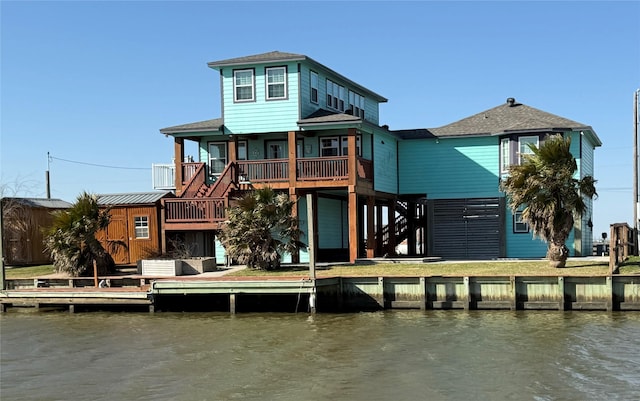 rear view of house with stairway and a water view