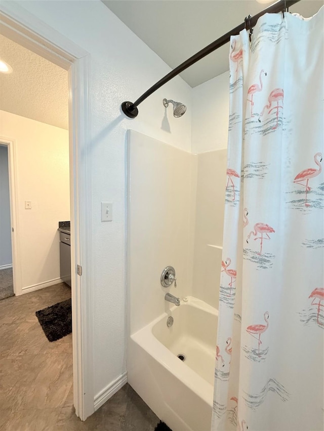 bathroom featuring baseboards, a textured ceiling, and shower / tub combo with curtain