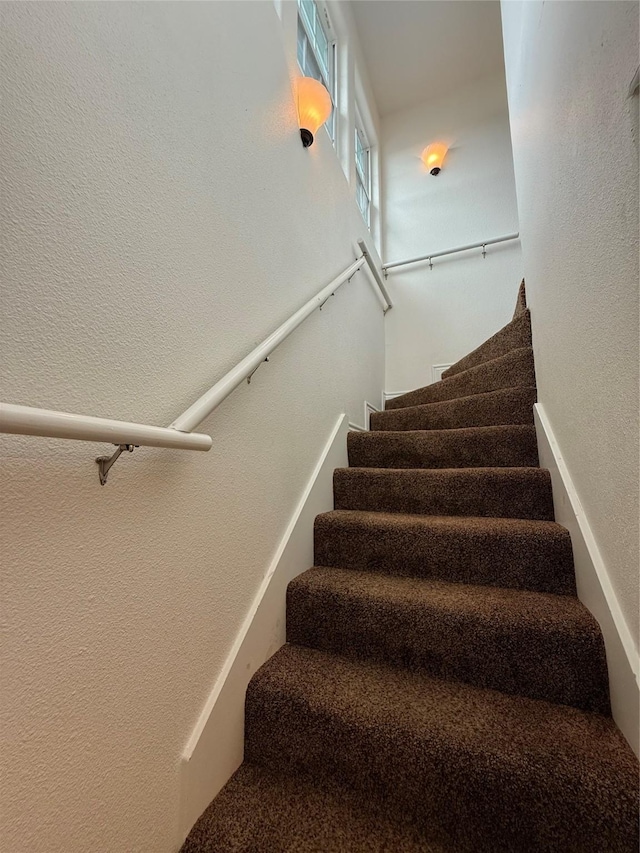 staircase featuring a textured wall