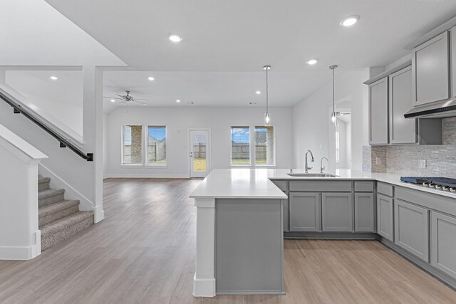 kitchen featuring a sink, stainless steel gas stovetop, a ceiling fan, and gray cabinetry