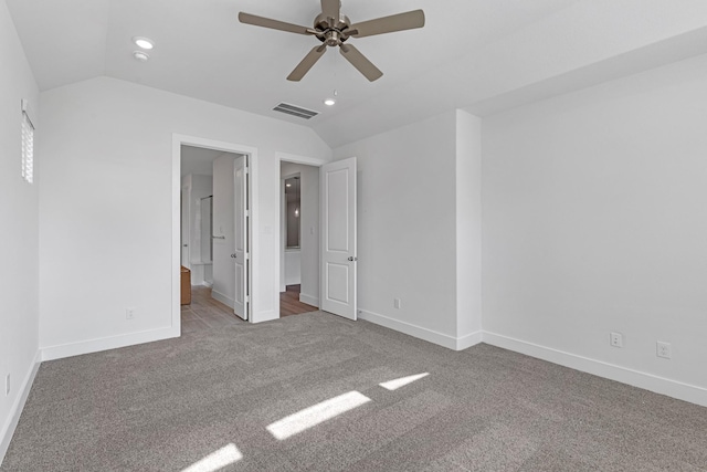 unfurnished bedroom with visible vents, carpet floors, baseboards, and vaulted ceiling