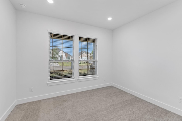 carpeted empty room featuring recessed lighting and baseboards