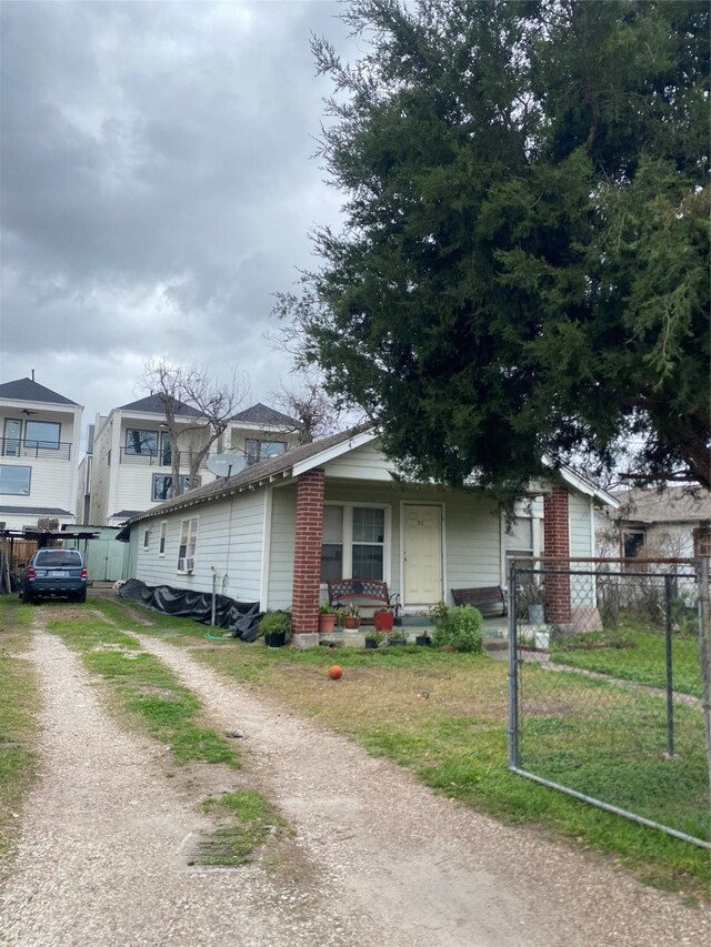 view of front of property featuring fence, a front yard, driveway, and a porch