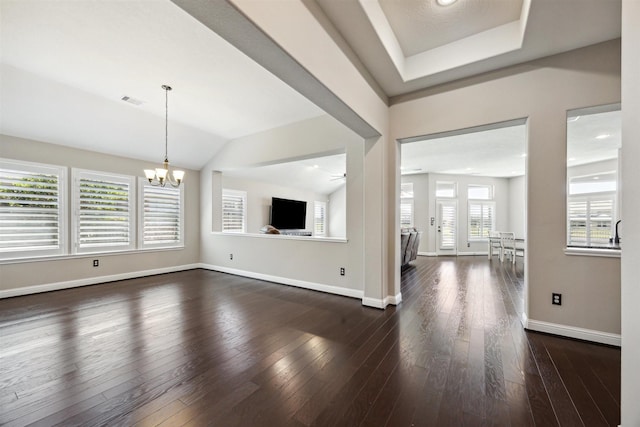 unfurnished living room featuring visible vents, baseboards, an inviting chandelier, and dark wood finished floors