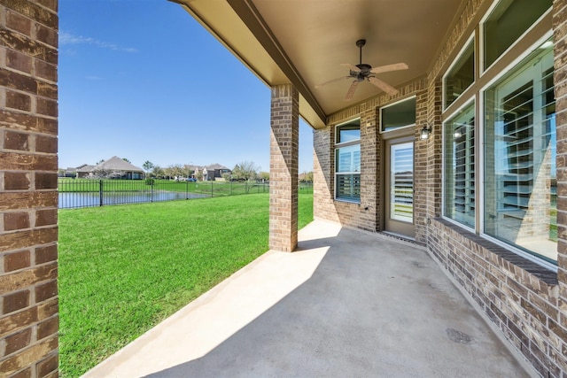 view of patio with a ceiling fan, a water view, and a fenced backyard