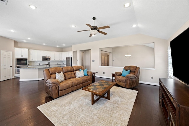 living area featuring dark wood-type flooring, baseboards, vaulted ceiling, recessed lighting, and ceiling fan with notable chandelier