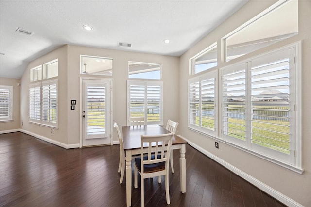 dining area with dark wood finished floors, a healthy amount of sunlight, visible vents, and baseboards