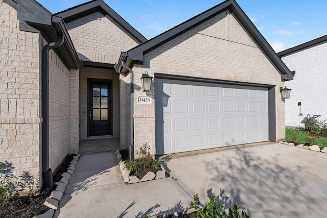 view of front of house with concrete driveway, a garage, and brick siding