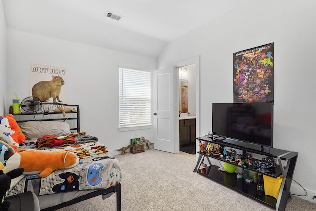 carpeted bedroom featuring visible vents, ensuite bath, and vaulted ceiling