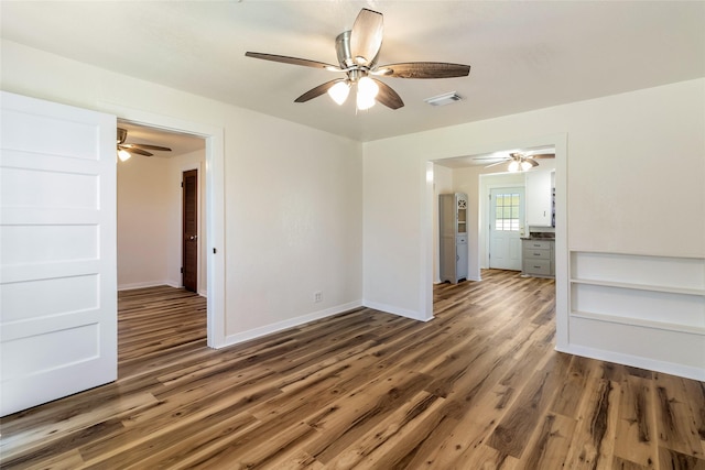 empty room with visible vents, baseboards, and wood finished floors