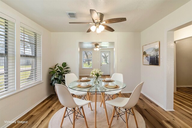 dining space featuring visible vents, light wood-style flooring, and baseboards