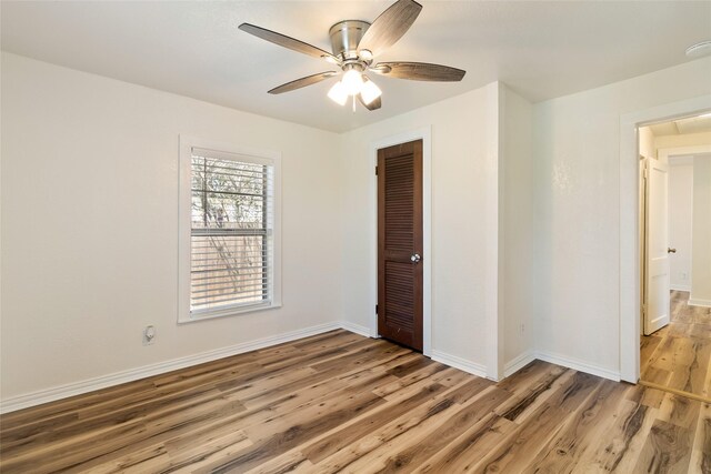 empty room with baseboards, light wood-type flooring, and ceiling fan