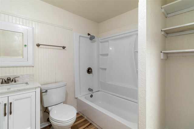 full bath featuring shower / bathing tub combination, toilet, wood finished floors, and vanity