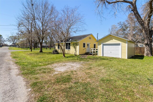 exterior space featuring driveway, a front yard, a garage, and fence