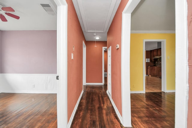 corridor featuring attic access, wood finished floors, visible vents, and baseboards