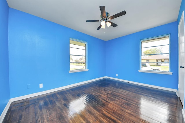 empty room with baseboards, a healthy amount of sunlight, and wood finished floors