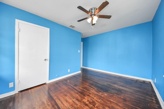 empty room featuring a ceiling fan, wood finished floors, visible vents, and baseboards