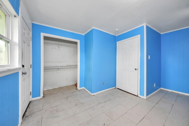 unfurnished bedroom featuring crown molding, baseboards, and a closet