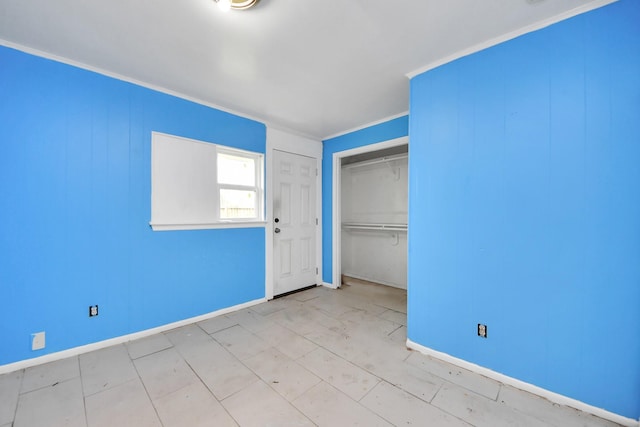 unfurnished bedroom featuring a closet, crown molding, and baseboards