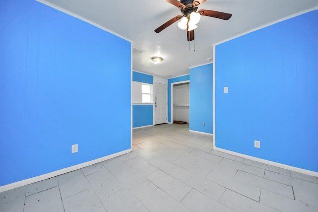 empty room with baseboards and a ceiling fan