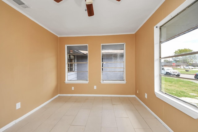 empty room featuring ceiling fan, visible vents, baseboards, and ornamental molding