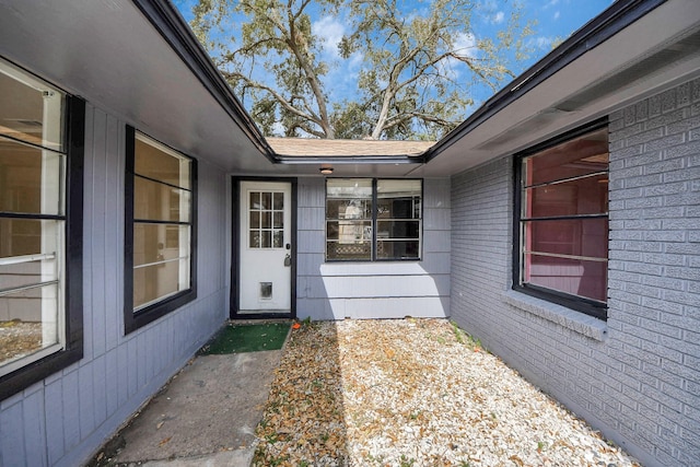 doorway to property featuring brick siding