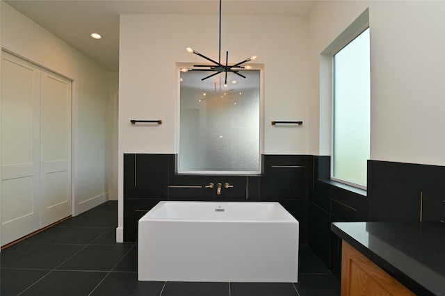 bathroom featuring tile patterned floors, a freestanding tub, and tile walls