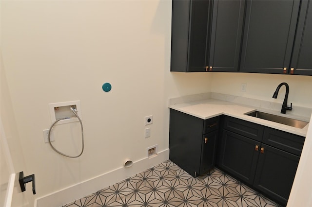 clothes washing area with baseboards, hookup for a washing machine, cabinet space, hookup for an electric dryer, and a sink