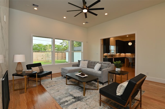 living area with light wood finished floors, visible vents, baseboards, ceiling fan, and recessed lighting