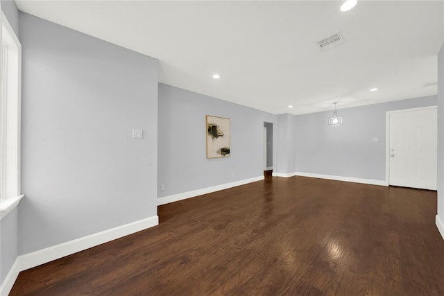 spare room with dark wood-style floors, recessed lighting, baseboards, and visible vents