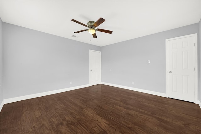 unfurnished room with dark wood-type flooring and baseboards