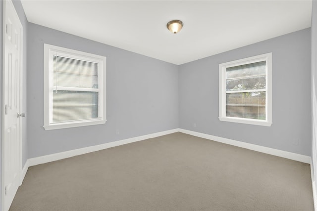 carpeted spare room with baseboards