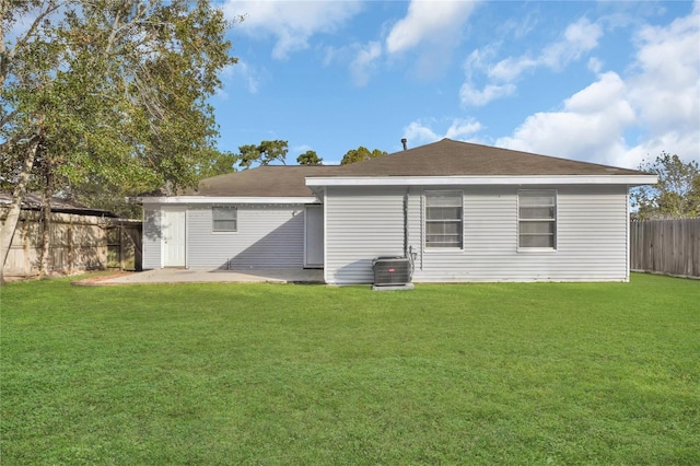 rear view of property featuring a patio area, a yard, a fenced backyard, and central AC