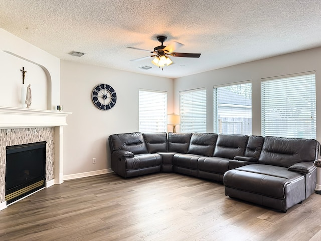 living room featuring visible vents, a fireplace, and wood finished floors