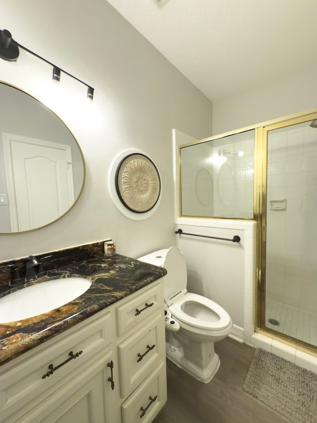 full bathroom with vanity, a shower stall, toilet, and wood finished floors