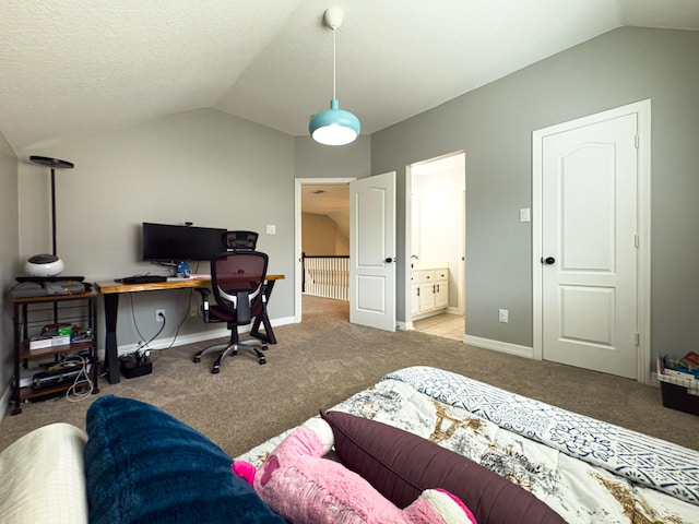 carpeted bedroom with a textured ceiling, vaulted ceiling, baseboards, and connected bathroom