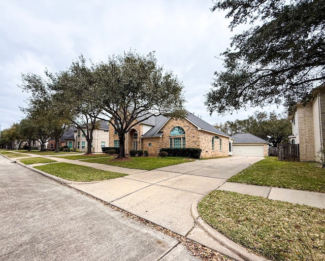 view of front of house featuring a front yard, a garage, fence, and brick siding