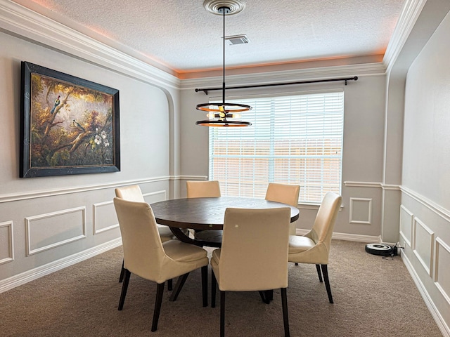 dining area featuring crown molding, a decorative wall, and carpet flooring