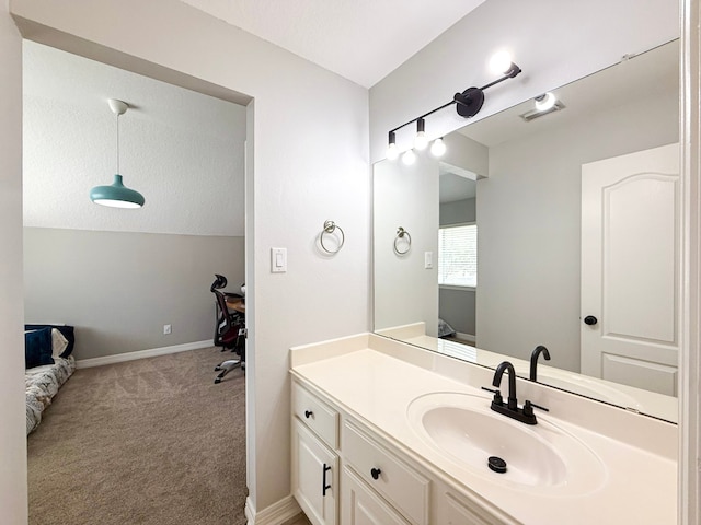 bathroom with a textured ceiling, vanity, baseboards, and vaulted ceiling