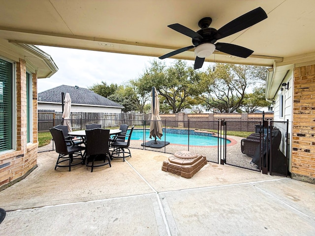 view of swimming pool featuring a fenced backyard, a patio, outdoor dining space, and a ceiling fan